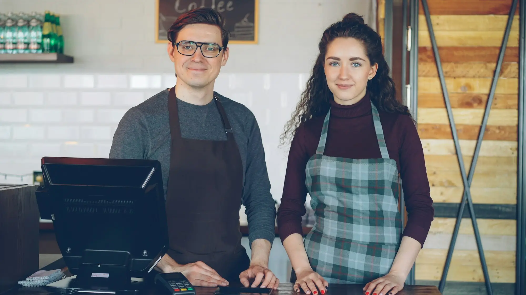 Cafe owners standing proudly behind their counter