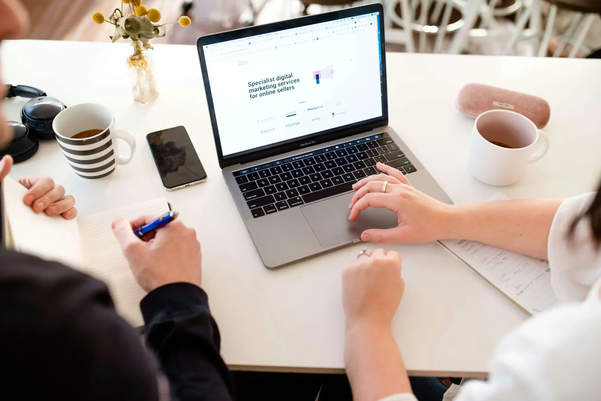Conveyancer signing mortgage documents beside a laptop