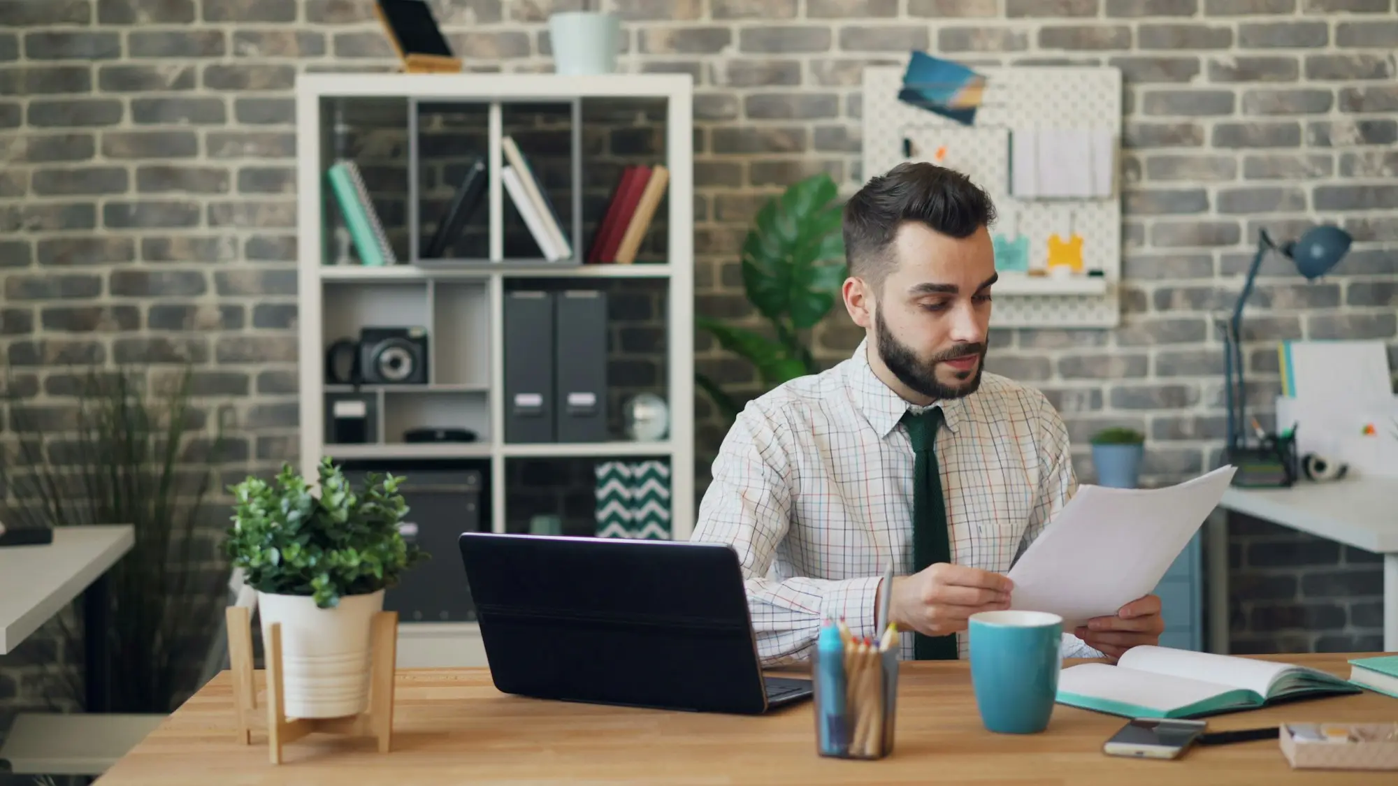 Business owner reviewing property papers at his office desk